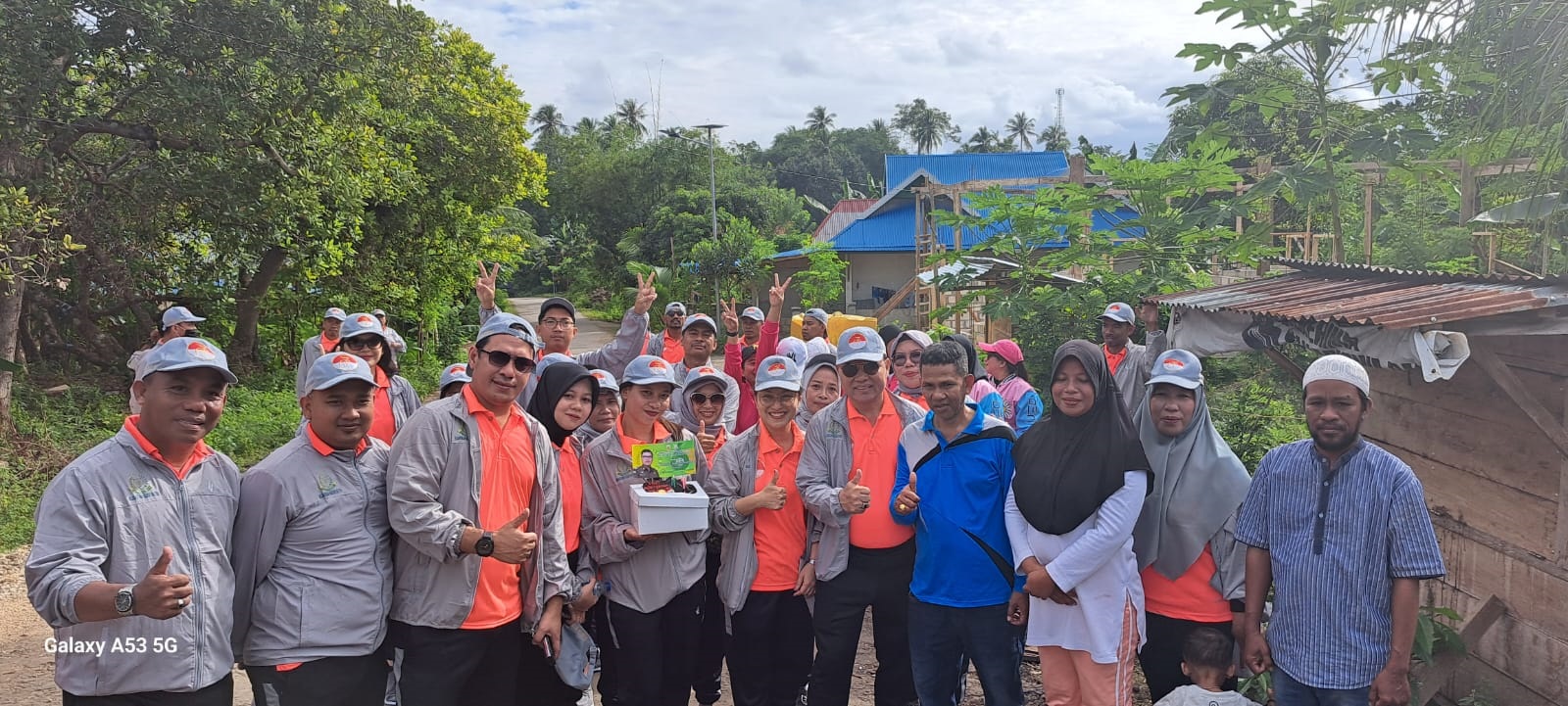 DICINTAI WARGA : Rombongan jalan sehat yang dipimpin Kajari Buton, Ledrik VM. Takaendengan, saat mendapat kejutan suguhan kue ulang tahun HBA ke-63 dari Lurah Kombeli, La Nurumai dan warganya. (ELYN IPO/KENDARI POS)