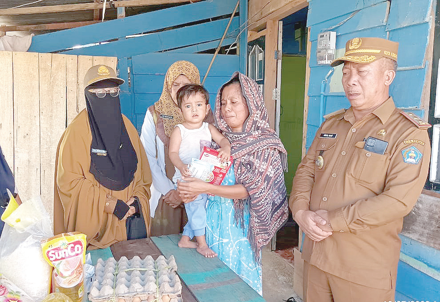 SALURKAN: Kepala Dinsos Kendari, Abdul Rauf (kanan) menyalurkan bantuan pangan kepada keluarga penderita stunting di Kawasan Pesisir Kota Kendari.