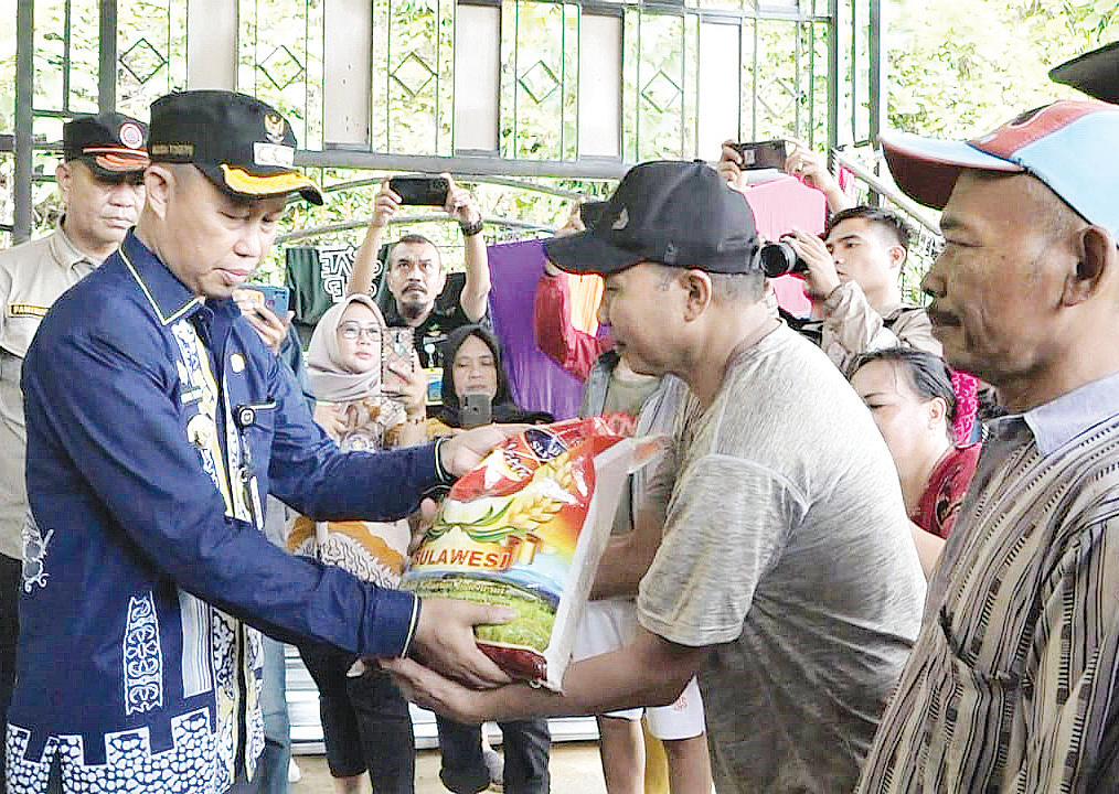 BANTUAN: Pj. Wali Kota Kendari, Asmawa Tosepu (kiri) menyerahkan bantuan kepada warga Mandonga yang terdampak longsor, kemarin. (Agus Setiawan/Kendari Pos)