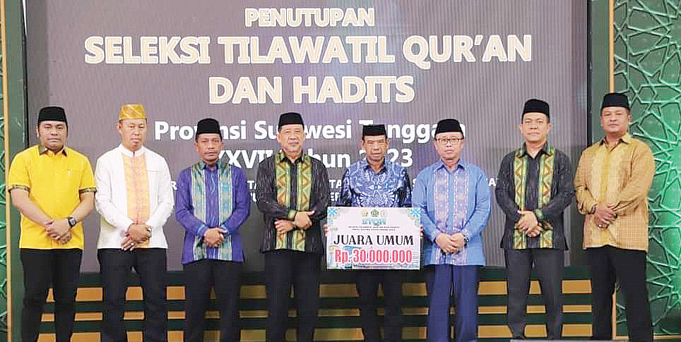 Plh Sekda Provinsi Sultra, Suharno (empat dari kiri) mewakili Gubernur Sultra menyerahkan uang pembinaan kepada daerah peraih juara umum STQH ke-27 tahun 2023. Turut mendampingi Kakanwil Kemenag Sultra, Muhamad Saleh (tiga dari kiri), Pj Wali Kota Kendari Asmawa Tosepu (dua dari kiri) dan sejumlah pejabat, dilanjutkan foto bersama usai penutupan STQH ke XXVIII di Claro Kendari, Selasa (18/7).