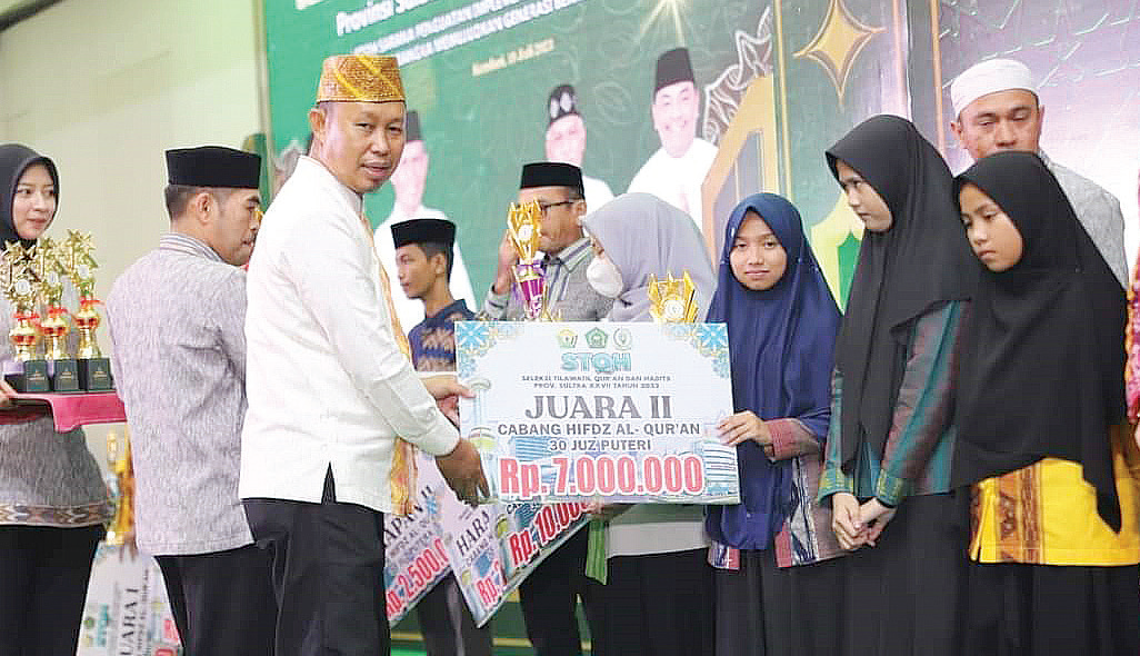 Pj Wali Kota Kendari, Asmawa Tosepu menyerahkan piala dan uang pembinaan kepada juara II Cabang Hifdz Al-quran. (Syahrul Sanip, Diskominfo Sultra)