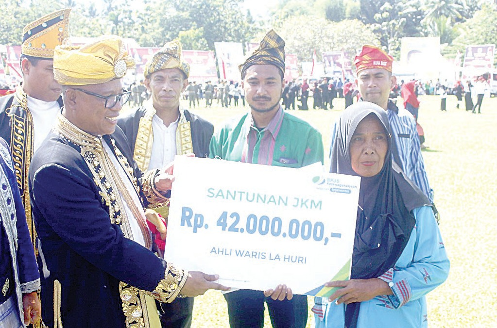 Pj. Bupati Mubar, Bahri memberikan santunan kepada enam orang ahli waris dari pekerja rentan yang didaftarkan sebagai peserta BPJS Ketenagakerjaan. (Akhirman/Kendari Pos)