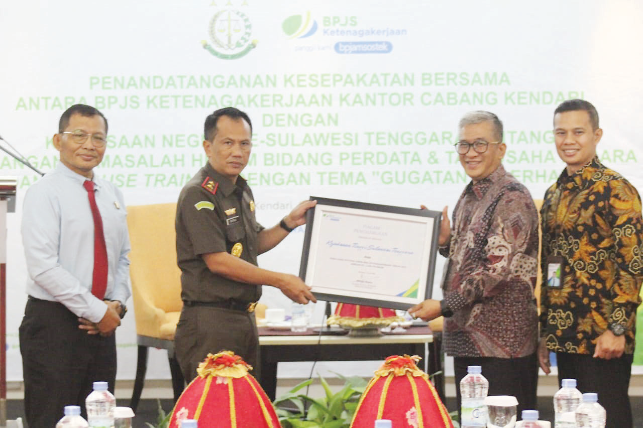 MoU: Kajati Sultra, Dr. Patris Yusrian Jaya bersama petinggi BPJS Ketenagakerjaan memperlihatkan piagam kerja sama, kemarin. (Kamaluddin/Kendari Pos)