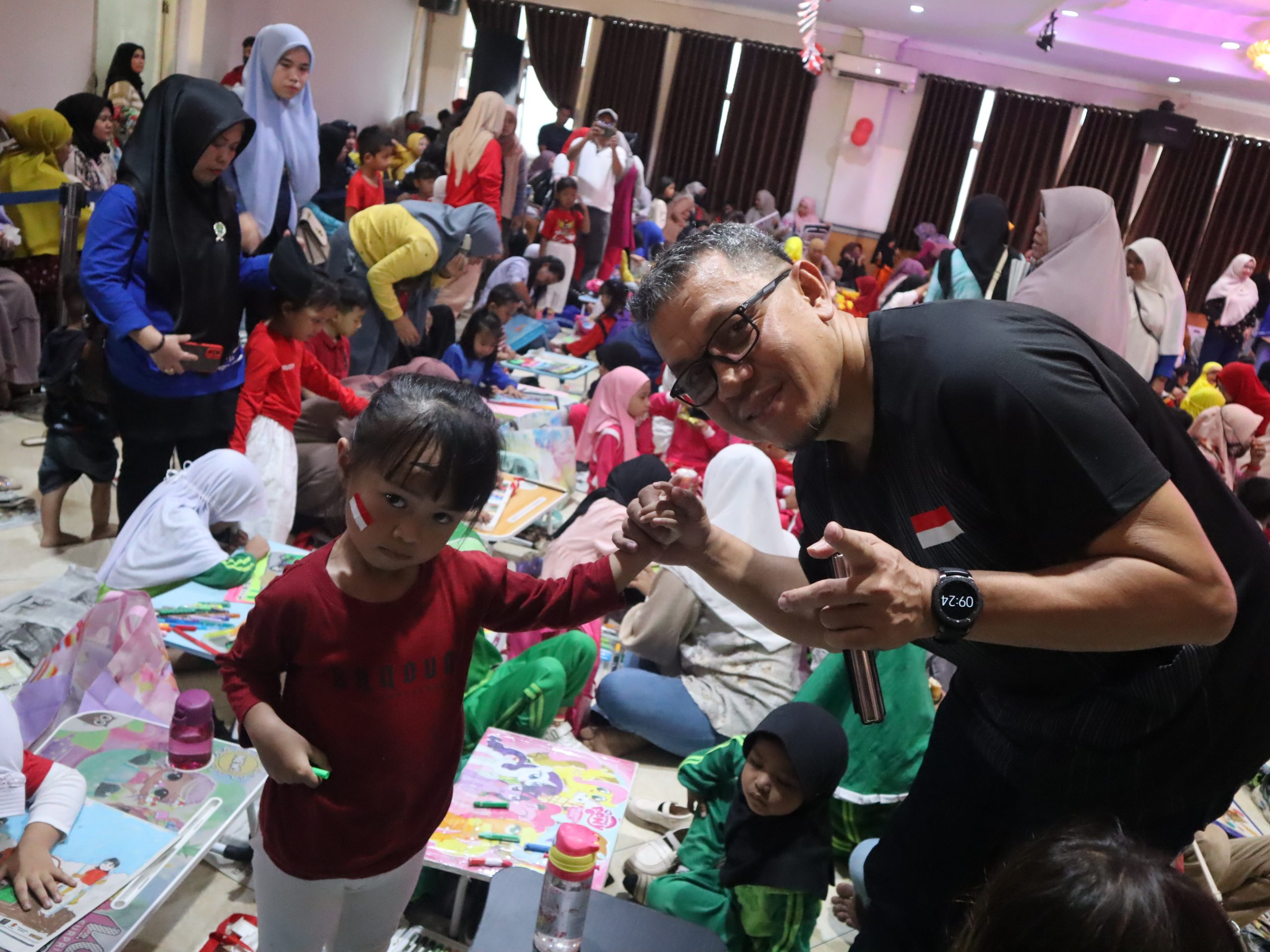 Momen Direktur Kendari Pos Irwan Zainuddin, bersama salah satu peserta lomba mewarnai