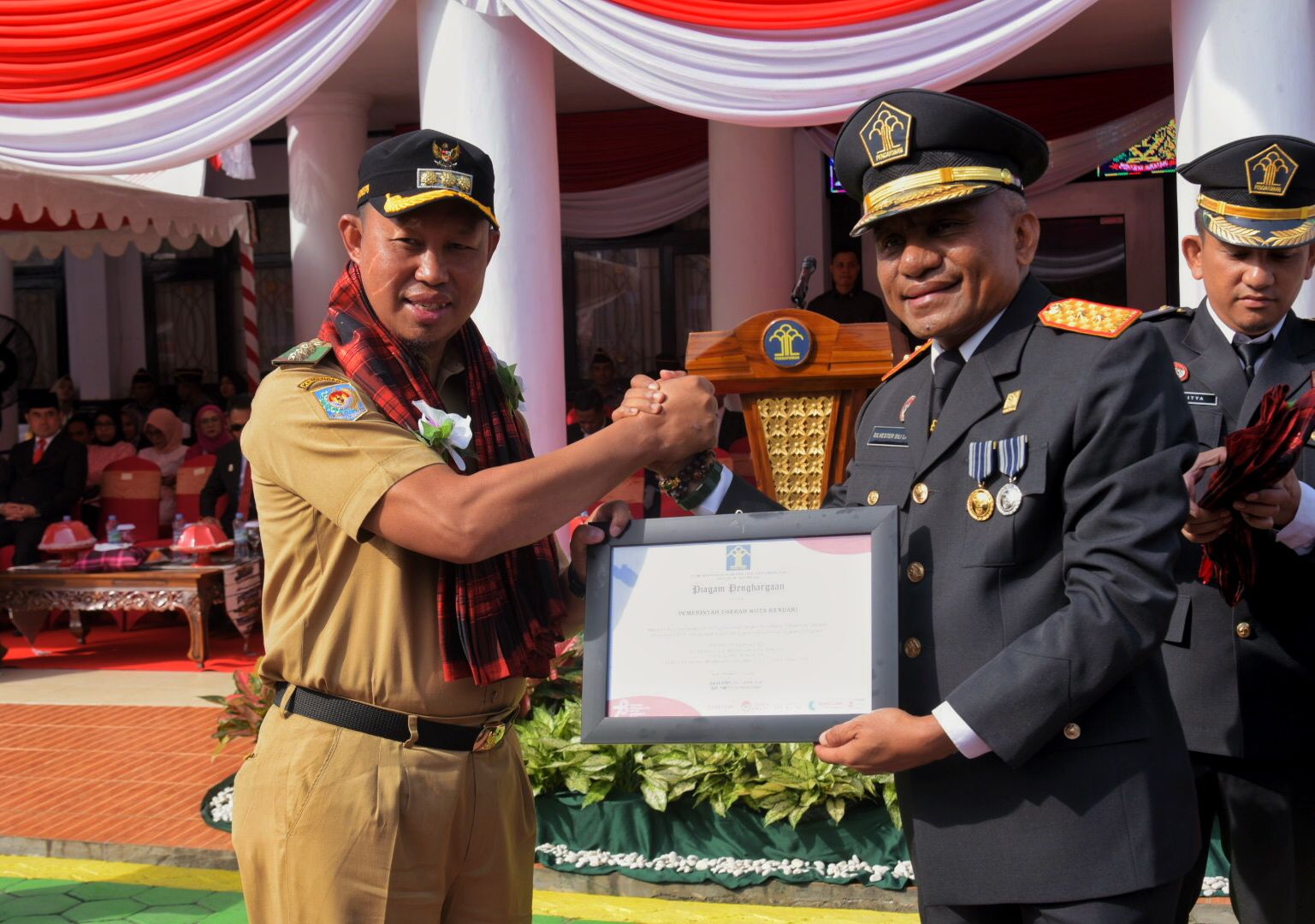 Pj.Wali Kota Kendari, Asmawa Tosepu (kiri) menerima penghargaan dari Kakanwil Kemenkumham Sultra, Silvester Sili Laba (kanan) atas kesuksesan Pemkot Kendari membantu pelaku UMKM mendapatkan legalitas usaha. Penghargaan diserahkan dalam acara Hari Dharma Karya Dhika (HDKD) di Kanwil Kemenkumham Sultra, Senin (21/8), kemarin.