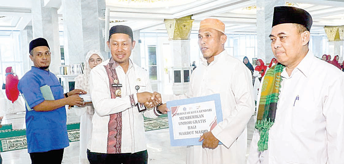 Pj Wali Kota Kendari, Asmawa Tosepu menyerahkan hadiah umrah gratis kepada marbot masjid.