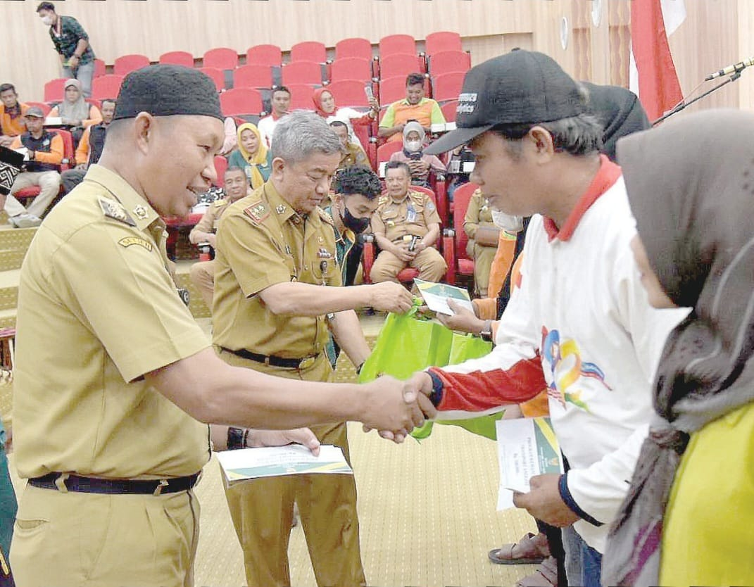 Penjabat (Pj) Wali Kota Kendari, Asmawa Tosepu (kiri) menyalurkan bantuan dana ZIS kepada petugas kebersihan di Balai Kota Kendari, Senin (25/9), kemarin. (HUMAS PEMKOT KENDARI)