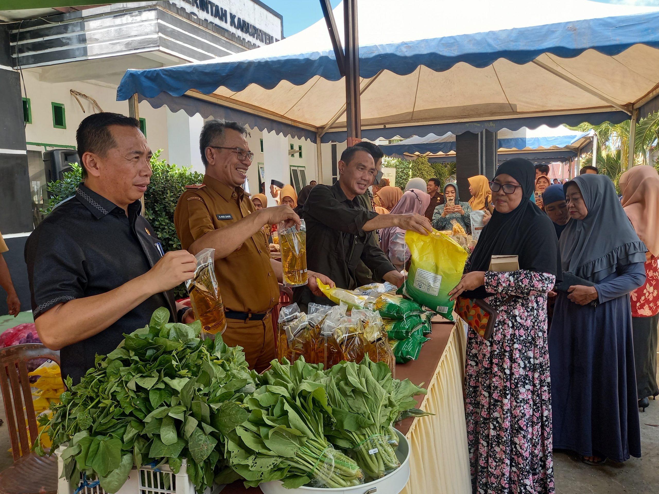 T EKAN INFLASI : Wakil Bupati Kolaka, H. Muhammad Jayadin (ketiga dari kiri) bersama Ketua DPRD, Syaifullah Halik (kiri) dan Pj Sekab, Muhamad Bakri (tengah) saat memantau gelar pangan murah, kemarin. (ZULFADLY NUR/KENDARI POS)