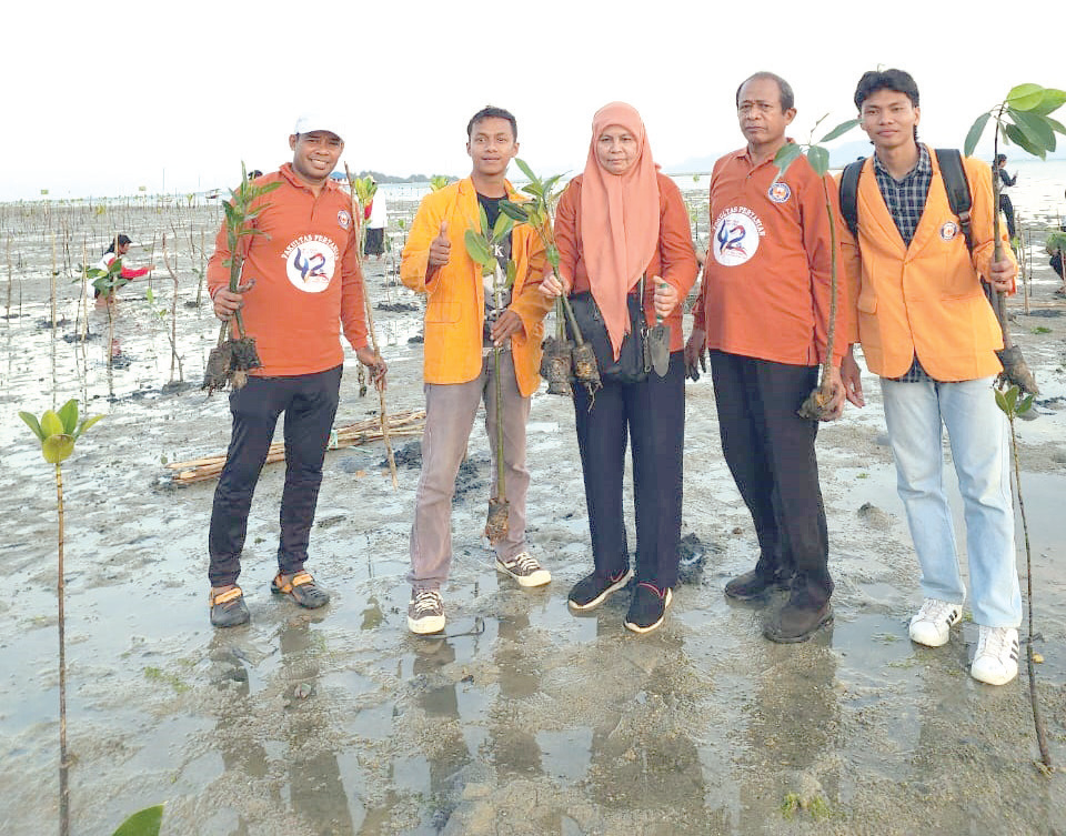 Foto bersama Tim PKMI UHO dan mahasiswa usai melakukan penanaman mangrove di pesisir Pantai Tapulaga sebagai bentuk partisipasi aktif dalam upaya pengelolaan lingkungan pesisir. (TIM PKM UHO FOR KENDARI POS)