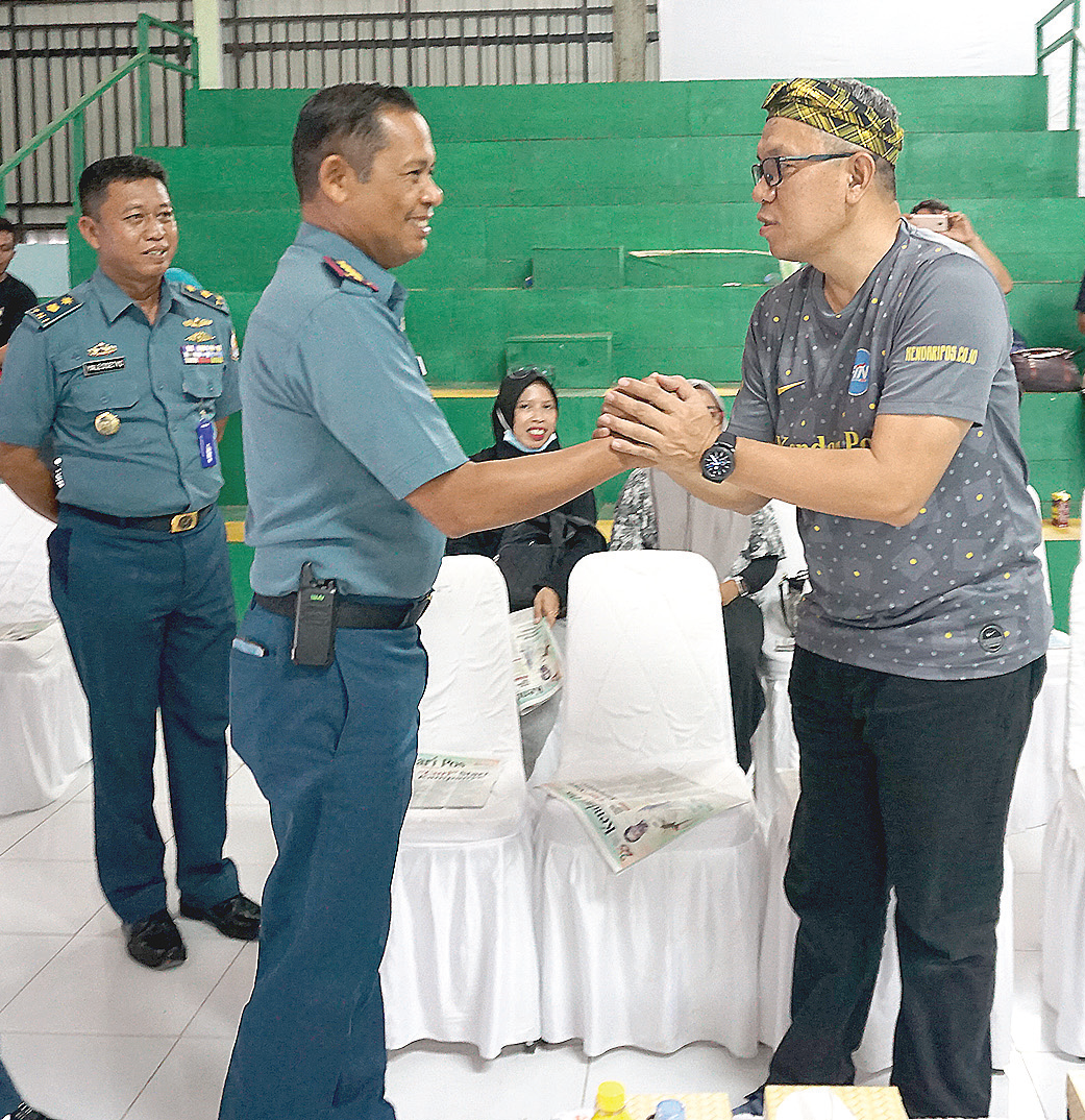 Direktur Kendari Pos Irwan Zainuddin (kanan), berjabat tangan dengan Komandan Lanal Kendari Kolonel Laut (P) Abdul Kadir Mulku Zahari (tengah).