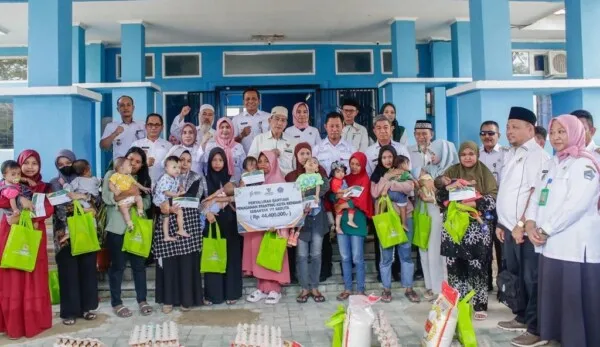 Pj Wali Kota Kendari Asmawa Tosepu (baris kedua, 3 dari kanan) dan jajaran Pemkot Kendari bersama masyarakat penerima bantuan makanan tambahan baduta untuk mencegah stunting, di pelataran Dinas Pengendalian Penduduk dan KB Kota Kendari, Rabu (15/11/2023), kemarin. (AGUS SETIAWAN / KENDARI POS)