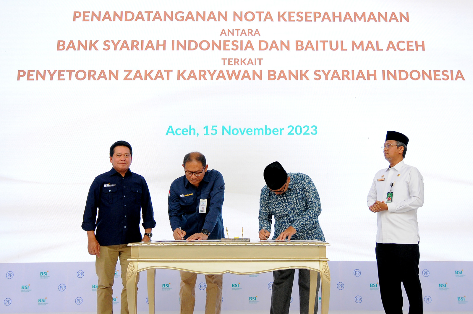 Direktur Utama BSI Hery Gunardi (kiri pertama) saat menyaksikan penandatanganan nota kesepahaman antara BSI Maslahat dengan Baitul Mal Aceh oleh Direktur Eksekutif BSI Maslahat Sukoriyanto Saputro (kiri kedua) dengan Ketua Badan Baitul Mal Aceh Mohammad Haikal (kanan kedua) yang disaksikan juga oleh Asisten 3 Provinsi Aceh Iskandar (kanan pertama), di acara Topping Off Green Building BSI Aceh, Banda Aceh (15/11).