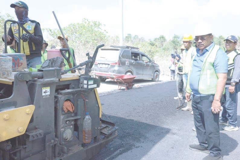 Burhanuddin (kanan) saat menjadi Penjabat (Pj) Bupati Bombana meninjau proyek pengaspalan jalan di Sikeli yang menghubungkan Kecamatan Kabaena Barat dan Kabaena Utara. (Maslindah Ali/Kendari Pos)