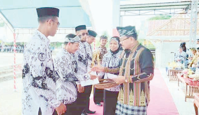 RAYAKAN MERDEKA BELAJAR: Bupati, Muh. Ridwan Zakariah (kanan) ketika menyerahkan penghargaan kepada sejumlah guru yang telah mengharumkan nama Buton Utara dan Provinsi Sulawesi Tenggara. (DOK. DISKOMINFO KABUPATEN BUTUR FOR KENDARI POS)