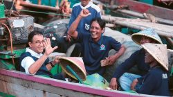 Anies (kiri) naik perahu dan berdiskusi dengan warga Kampung Nelayan, Desa Kronjo, Tangerang. (TIM MEDIA ANIES-MUHAIMIN)