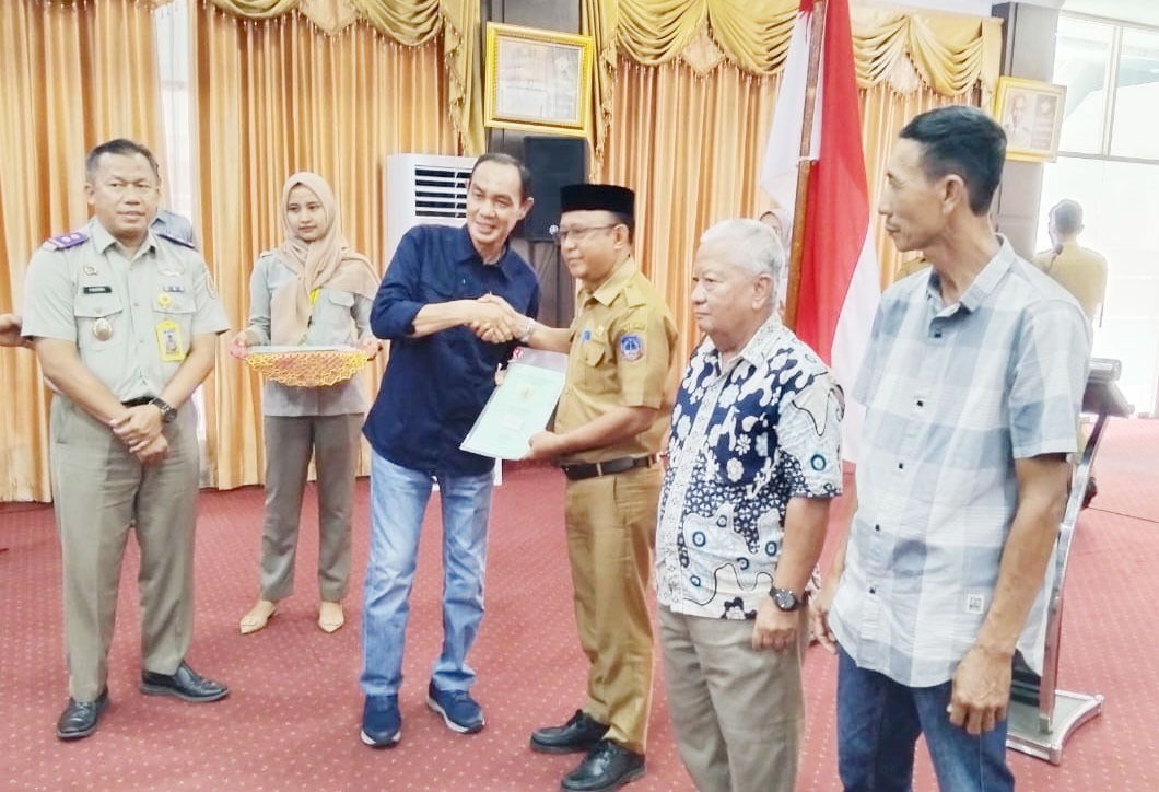 LEGALITAS TANAH : Plt Bupati Kolaka, Muhammad Jayadin (keempat dari kanan), secara simbolis menyerahkan sertifikat tanah program PTSL kepada Kabag Pemerintahan Setkab, Muhammad Jufri, kemarin. (ZULFADLY NUR/KENDARI POS)