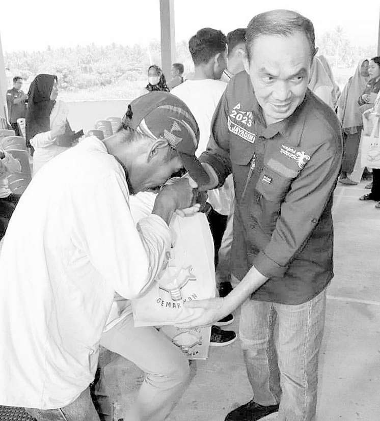 DANA PUSAT : Plt Bupati Kolaka, H. Muhammad Jayadin (kanan) ketika turun langsung menyerahkan bantuan Sembako kepada warga di Kecamatan Pomalaa, kemarin. (DISKOMINFO KOLAKA FOR KENDARI POS)