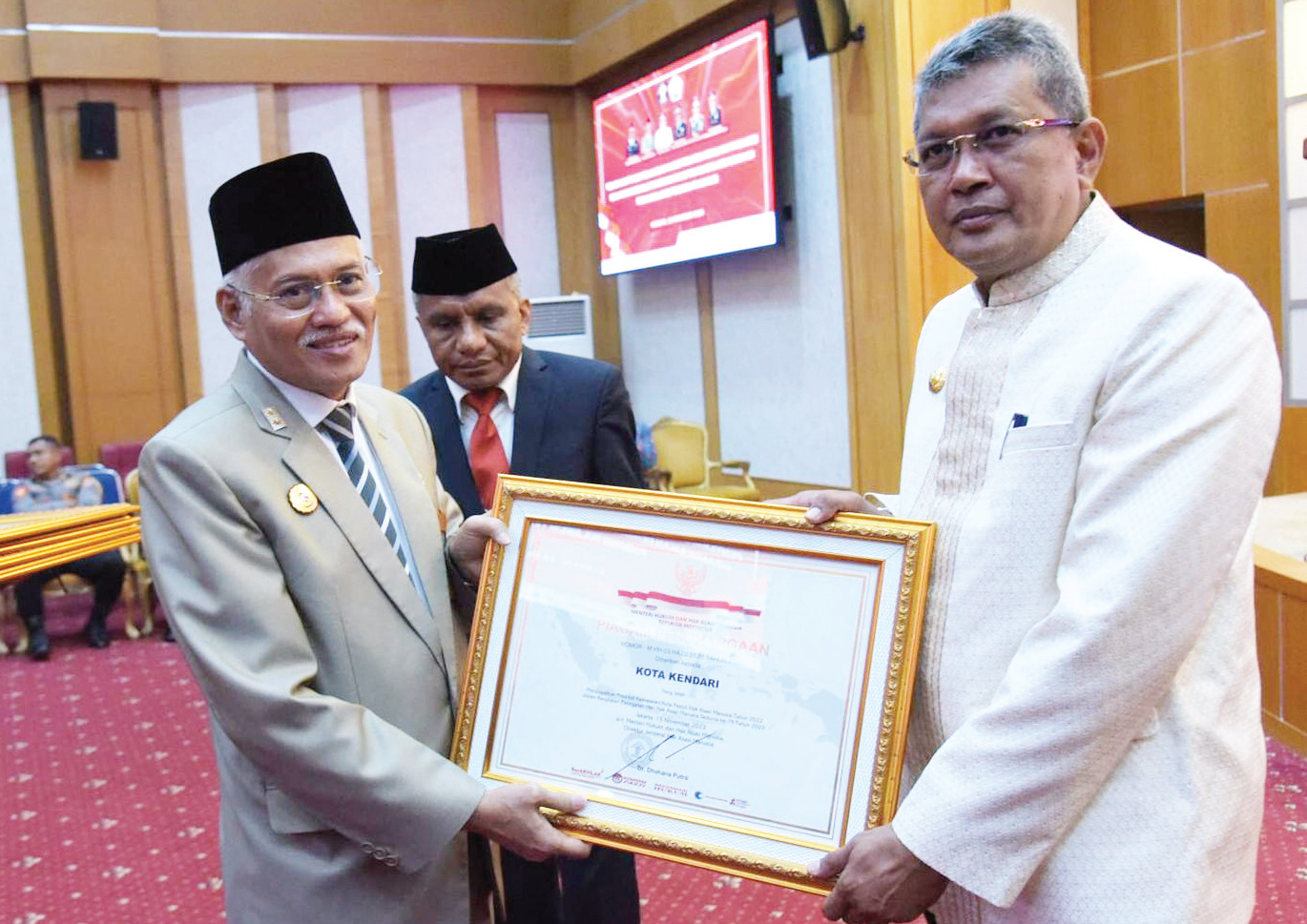 PENGHARGAAN KOTA PEDULI HAM : Penjabat Wali Kota Kendari, Muhammad Yusup (kanan) menerima penghargaan Kota Peduli HAM dari Sekprov Sultra Asrun Lio (kiri) didampingi Kepala Kanwil Kemenkumham Sultra Silvester Sili Laba (tengah) di ruang pola kantor Setprov Sultra kemarin. (AGUS SETIAWAN/KENDARI POS)