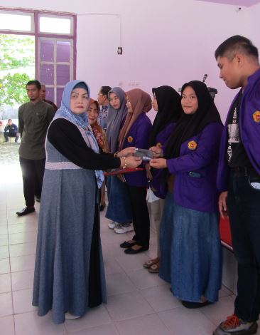 Rektor Universitas Lakidende (Unilaki) Prof. Dr.Hj.Rostin, SE., MS (kiri) menyerahkan buku tabungan KIP Kuliah kepada perwakilan 79 mahasiswa di kampus Unilaki, Jumat (12/1/2024). (ADI HIDAYAT/KENDARI POS)