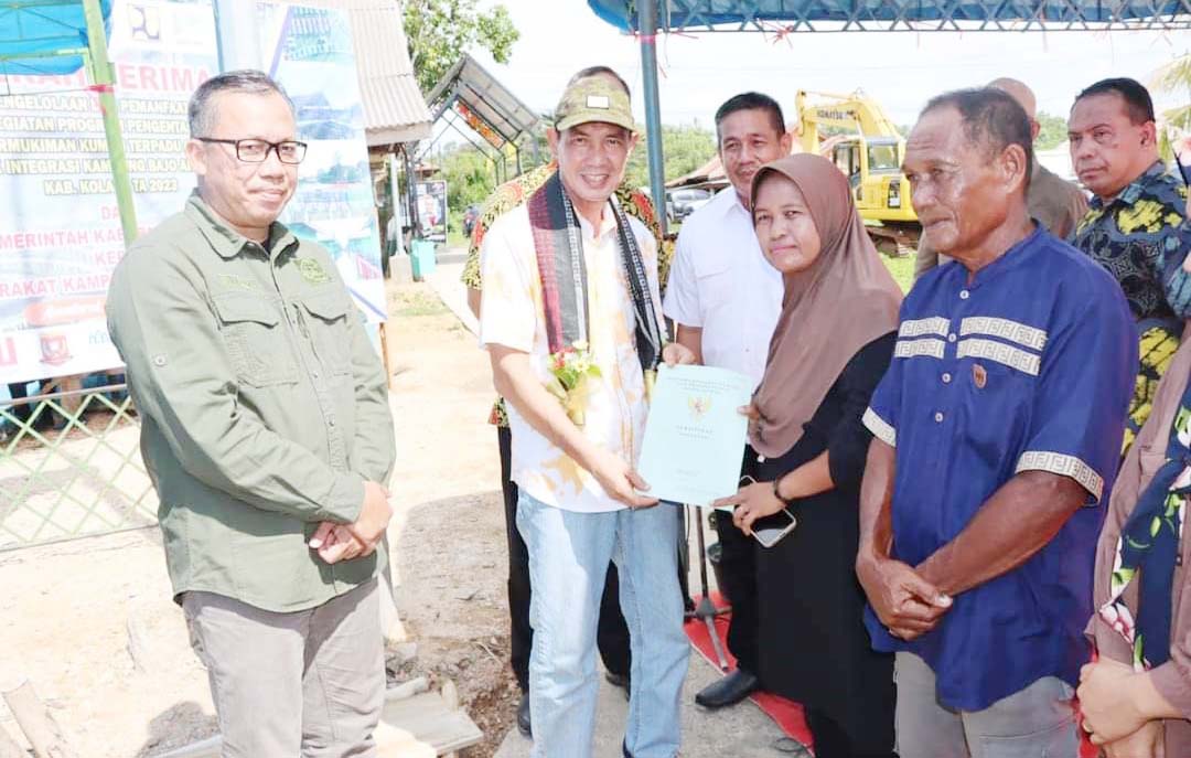 LEBIH TERTATA : Plt Bupati Kolaka, H. Muhammad Jayadin (kedua dari kiri) menyerahkan secara simbolis pengelolaan dan pemanfaatan PPKT DAK integrasi kepada masyarakat Kampung Bajo di Kelurahan Anaiwoi. (ZULFADLY NUR/KENDARI POS)