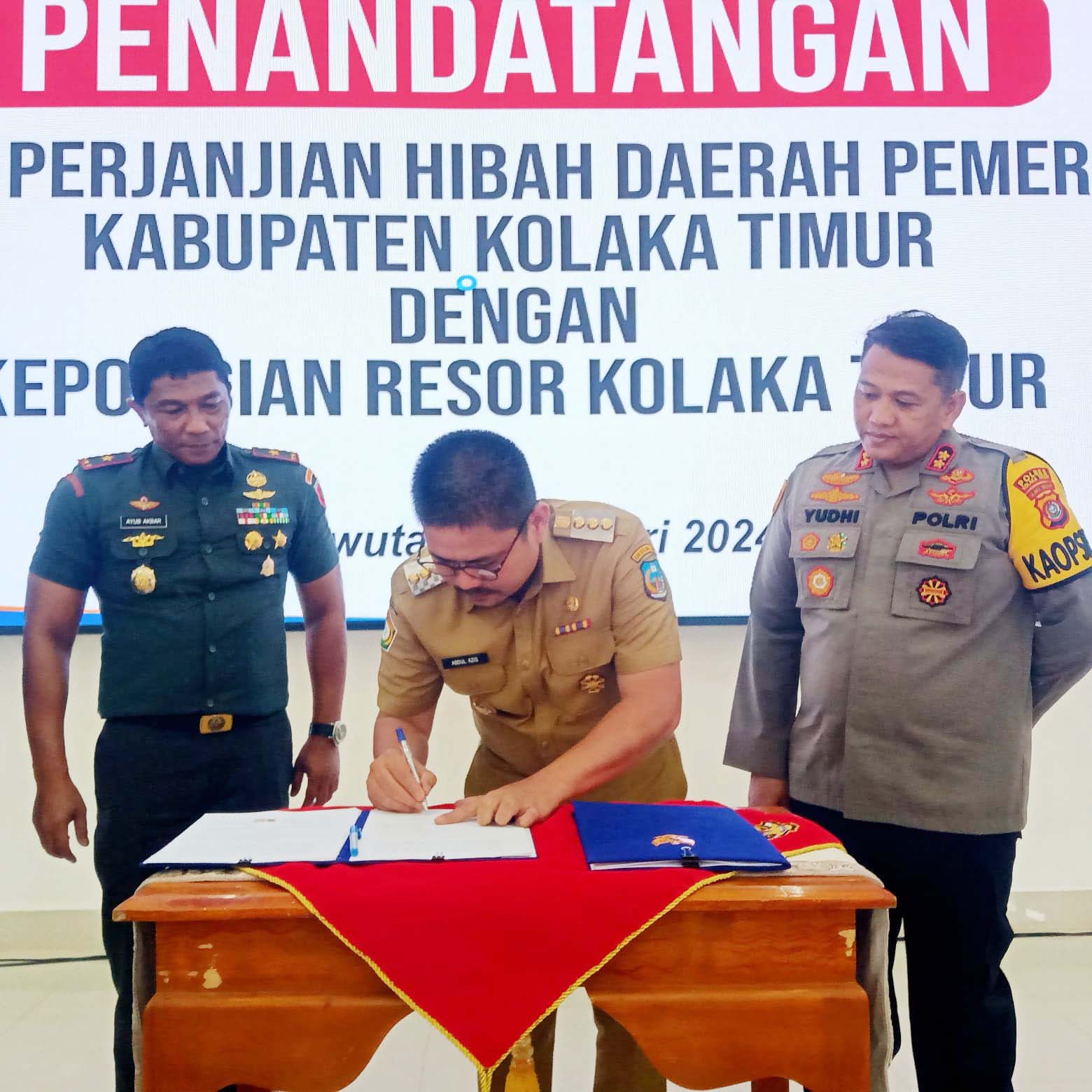 TUNTAS : Bupati Koltim, Abdul Azis (tengah) ketika menandatangani naskah perjanjian hibah daerah terkait alokasi dan distribusi anggaran pengamanan Pilkada bagi lembaga TNI dan Kepolisian. (KUSDIN/KENDARI POS)