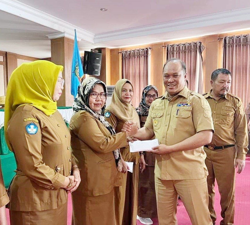 MERIAHKAN HUT DAERAH : Bupati Konut, Ruksamin (kanan) saat menyerahkan dana apresiasi pada murid SDN yang terlibat sebagai peserta musik bambu Festival Konasara yang diterima langsung oleh para kepala Sekolah (HELMIN TOSUKI/KENDARI POS)