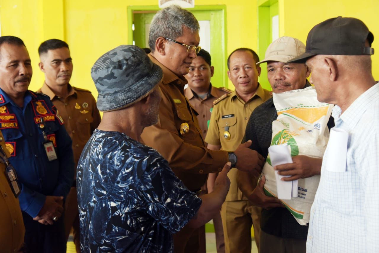 Pj Wali Kota Kendari, Muhammad Yusup (tengah) didampingi Kepala Dinas Ketahanan Pangan (Disketapang) Kota Kendari, Abdul Rauf (3 dari kanan) menyalurkan bansos beras secara simbolis di Kelurahan Gunung Jati, Senin (29/1/2024). (AGUS SETIAWAN / KENDARI POS)