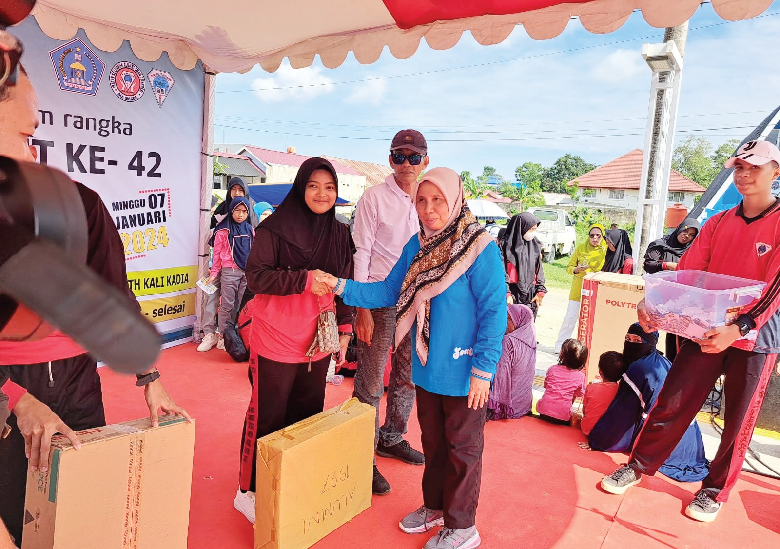 Kepala SMAN 2 Kendari Nur Aida (baju biru) saat menyerahkan doorprize kepada salah satu peserta yang beruntung. (EWIN ENDANG SAHPUTRI/KENDARI POS)