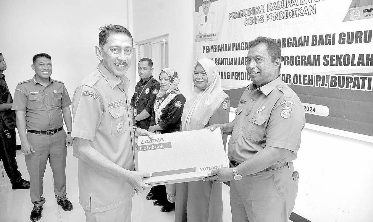 BANTUAN LAPTOP: Pj Bupati Buton La Ode Mustari (kiri), menyerahkan bantuan laptop ke sekolah penggerak. (erlin ipo/kendari pos)