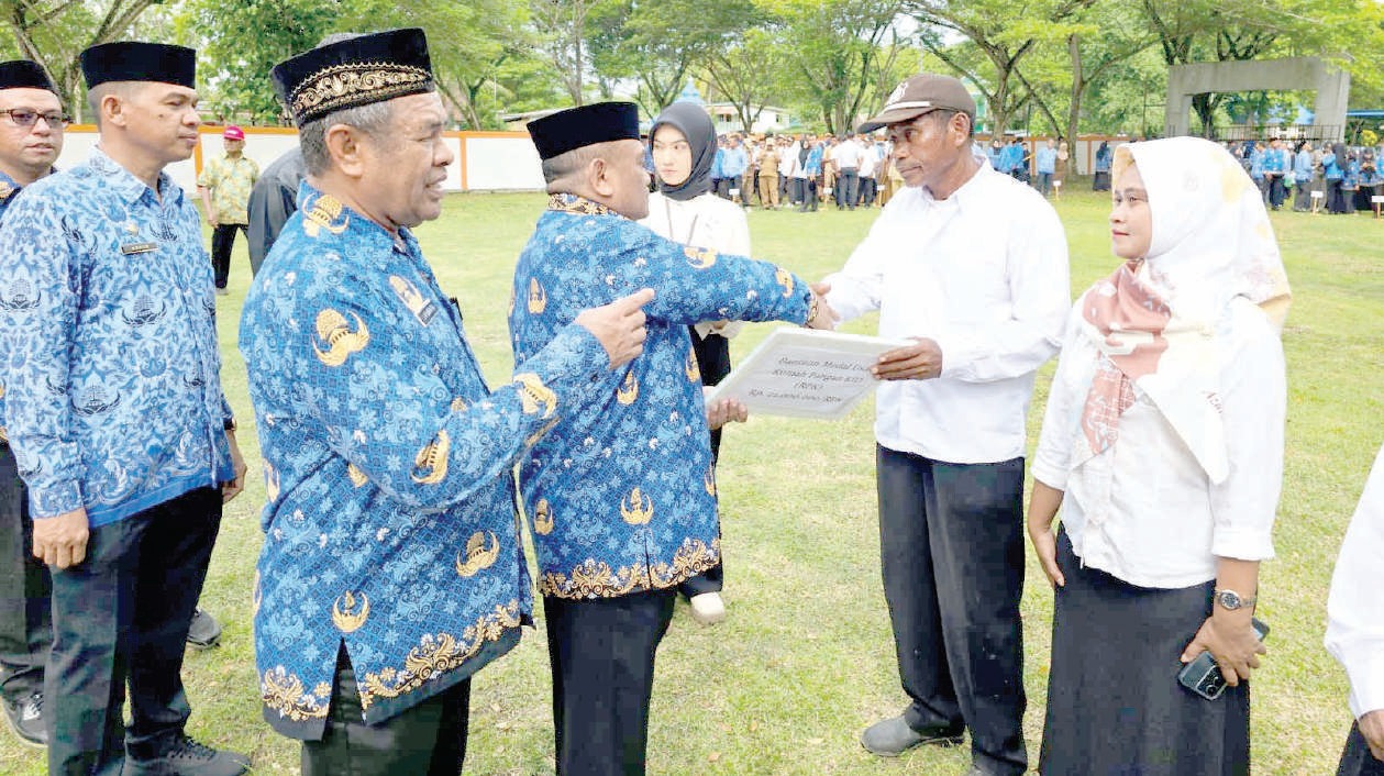 Pj Bupati Mubar, La Ode Butolo (depan/bersalaman) menyerahkan insentif tambahan bagi ketua RT di Mubar. Tampak Sekab Mubar, LM Husein Tali (tengah) dan Kepala BPMD Mubar, Aswin (belakang) mendampingi. (Akhirman/Kendari Pos)