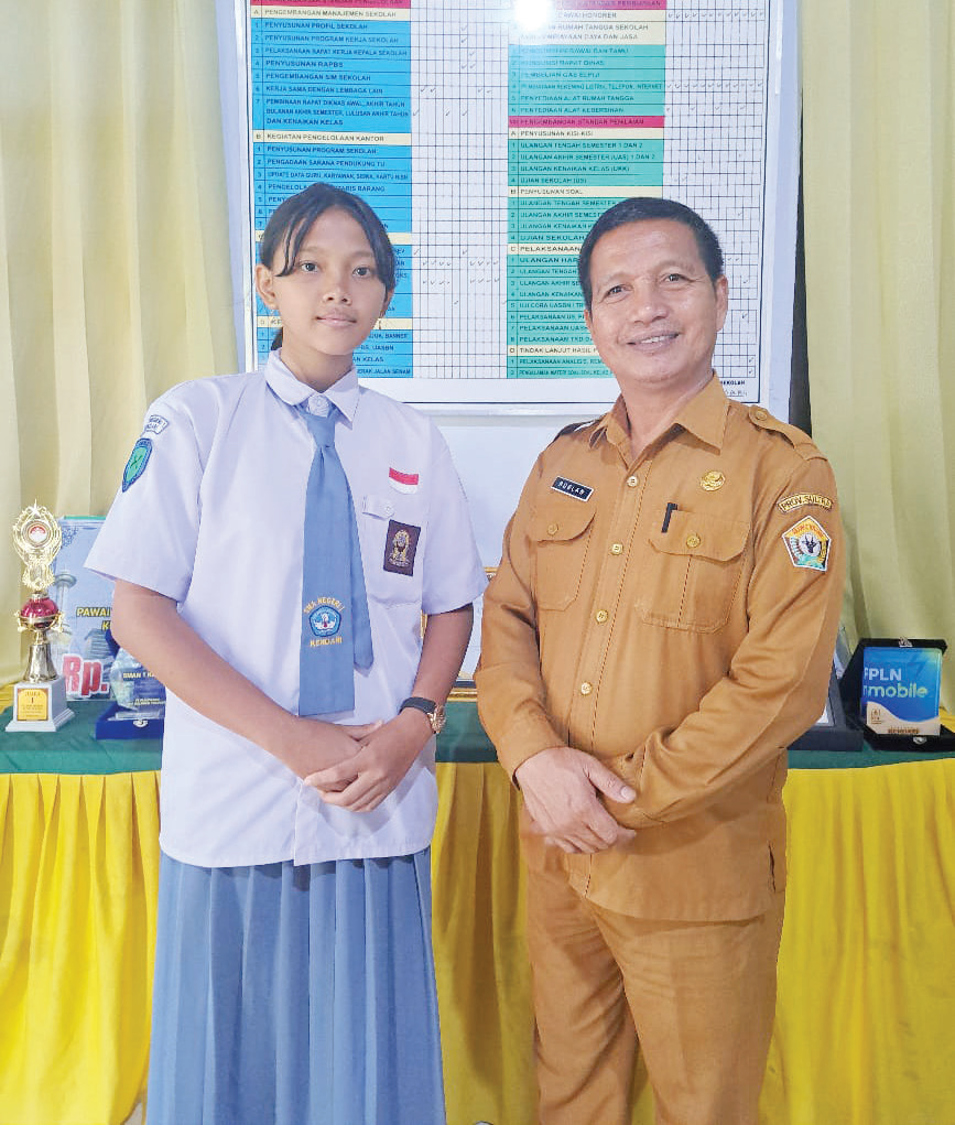 Foto bersama Kepala SMAN 1 Kendari, Ruslan (kanan) dan Diva Maheswari Nadiguna Somayasa (kiri). (EWIN ENDANG SAHPUTRI/KENDARI POS)