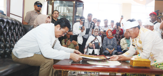 Mantan Gubernur Sultra Nur Alam (kiri) menerima Kalo Sara dalam penyambutannya secara adat oleh tokoh adat Tolaki di ruang tunggu VIP bandara Halu Oleo, Kamis (18/1/2024). (Muh. Abdi Asmaul Amrin/Kendari Pos)