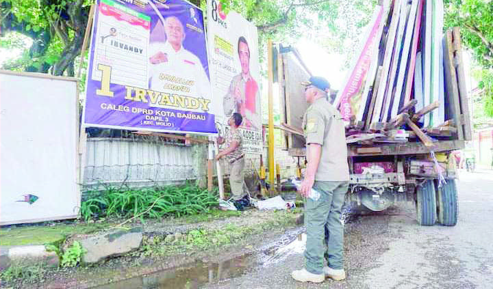 LANGGAR ATURAN : Suasana penertiban sejumlah aPK yang dipasang tidak pada tempat yang ditetapkan KPU. Pemkot Baubau bersama stakeholder terkait akan terus melakukan penertiban hingga akhir pekan ini. (ANJAR DISKOMINFO KOTA BAUBAU FOR KENDARI POS)