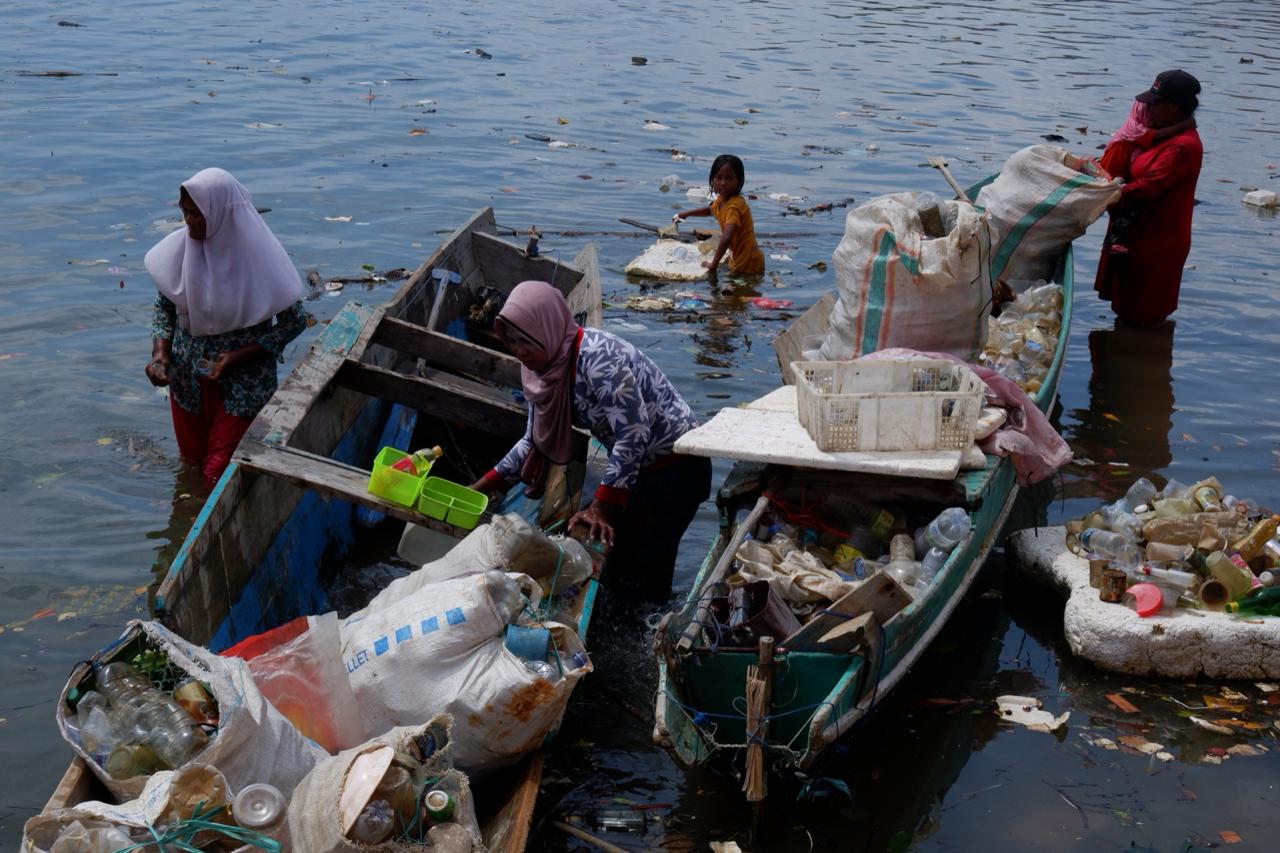 Perempuan pesisir Kota Kendari, membawa serta anak dan cucu, memulung sampah laut di Teluk Kendari. Para perempuan ini rata-rata menggantungkan hidup dari aktivitas memulung dan mencari kerang. (YULI/KENDARI POS)