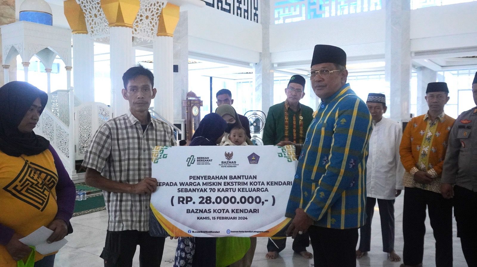 Pj Wali Kota Kendari Muhammad Yusup (kanan) menyerahkan bantuan secara simbolis kepada masyarakat miskin ekstrem dalam acara peringatan Isra Mikraj Nabi Muhammad SAW di Masjid Al Alam, Kamis (15/2/2024). (AGUS SETIAWAN / KENDARI POS)