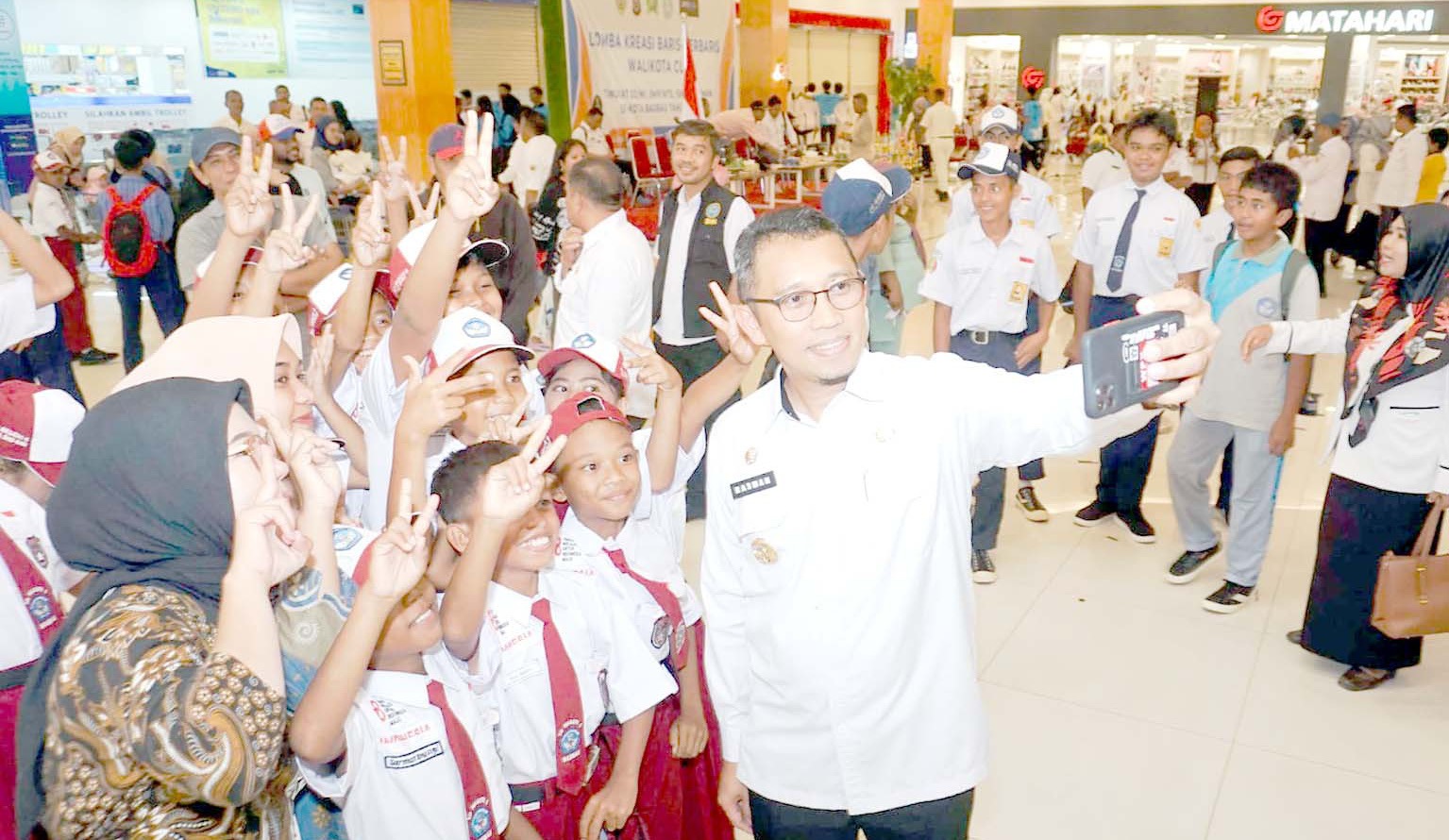 BERDAYA SAING Pj Wali Kota Baubau, Muh. Rasman Manafi saat berswafoto dengan anak sekolah ketika membuka lomba kreasi baris-berbaris Wali Kota Cup I. (DISKOMINFO KOTA BAUBAU FOR KENDARI POS)