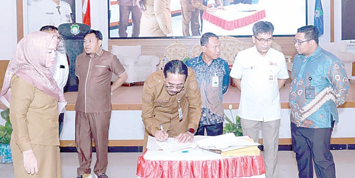 Pj Bupati Bombana, Edy Suharmanto, menekan dokumen kerjasama dengan Bank Sultra mengenai program literasi keuangan daerah. Disaksikan Direktur Kepatuhan Bank Sultra Hariyanto. (MASLINDAH/KENDARI POS)