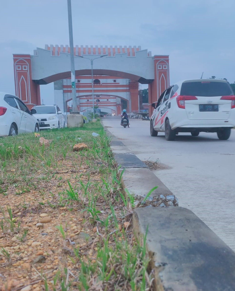 GERBANG JALAN WISATA : Pembangunan gerbang jalan wisata Kendari-Toronipa telah masuk tahap finishing. Saat ini, satu jalur sudah bisa dilewati. Kendaraan melintas di jalan wisata, Kamis (15/2). (AMAL FADLY SENGA/KENDARI POS)