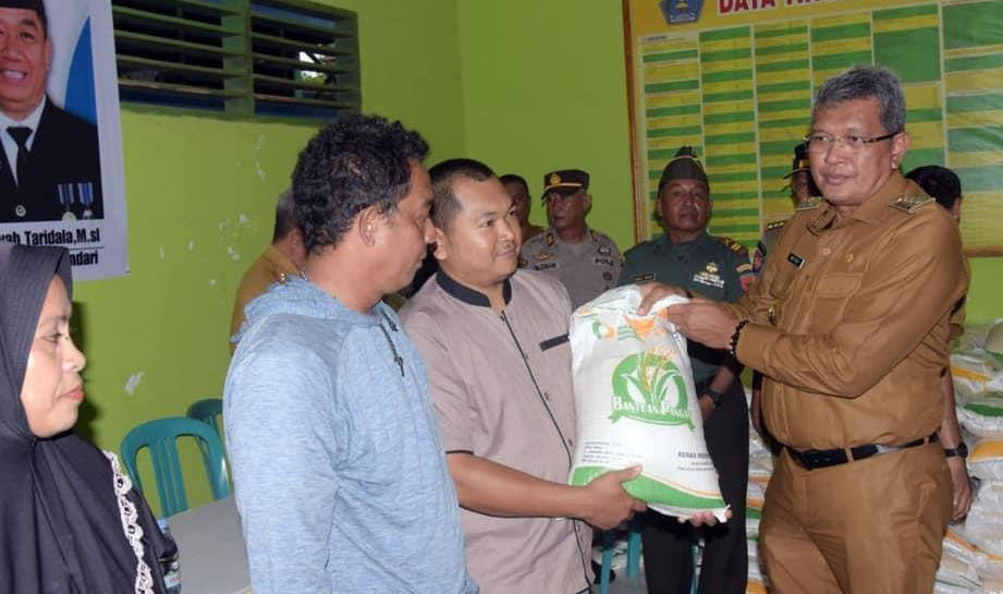 PENYALURAN BANSOS : Pj Wali Kota Kendari, Muhammad Yusup (paling) menyalurkan bantuan pangan kepada masyarakat kurang mampu. (AGUS SETIAWAN/KENDARI POS)