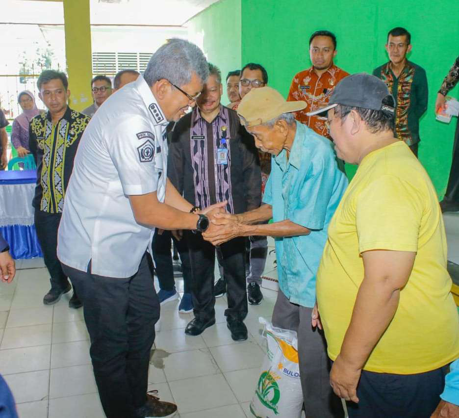 BANTUAN PANGAN : Pj Wali Kota Kendari, Muhammad Yusup menyalurkan bantuan pangan di Kelurahan Puuwatu, kemarin. (AGUS SETIAWAN/KENDARI POS)