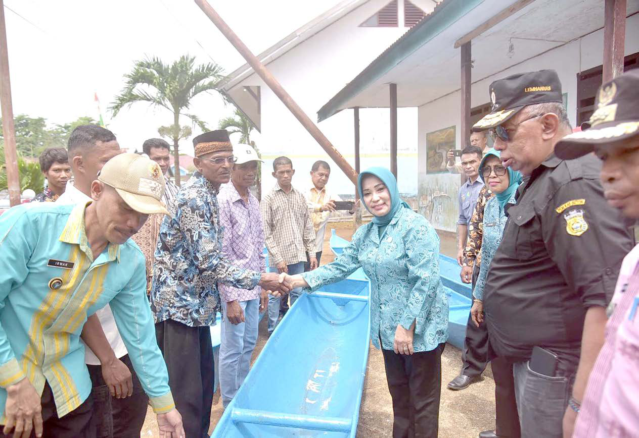 PeDuLi: Pj Ketua PKK buton, Dra. andi asniwati, menyerahkan bantuan perahu kepada nelayan. (ELYN/KENDARI POS)