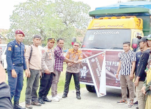 A nggota KPU Sultra, Amiruddin (pertama dari kanan/pegang baliho) ditemani Ketua KPU Mubar, La Tajudi (kedua dari kanan/pegang baliho) dan beberapa anggota komisioner KPU Mubar saat melakukan pelepasan pendistribusian logistik Pemilu. (KPU Mubar for Kendari Pos)