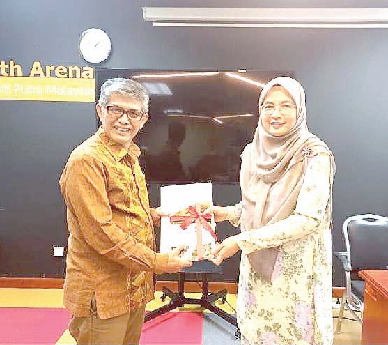Ketua Pengarah IPSAS UPM Malaysia, Prof. Haslinda Abdullah (kiri) saat memberikan cinderamata kepada Dekan Fisip UHO, Prof. Dr. Eka Suaib, M.Si., (kanan) usai memberi kuliah tamu di IPSAS. (FISIP UHO FOR KENDARI POS)
