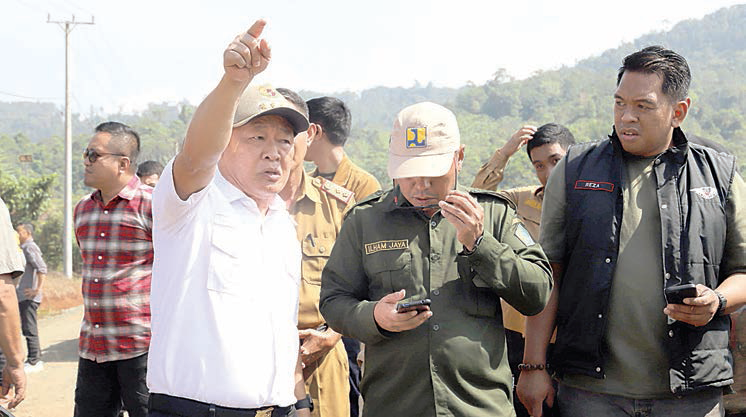 Pj Bupati Konawe, Harmin Ramba didampingi Kadis PUPR, Ilham Jaya saat meninjau rencana pengaspalan jalan di Desa Tanggola, Kecamatan Routa. (ADI HIDAYAT/KENDARI POS)