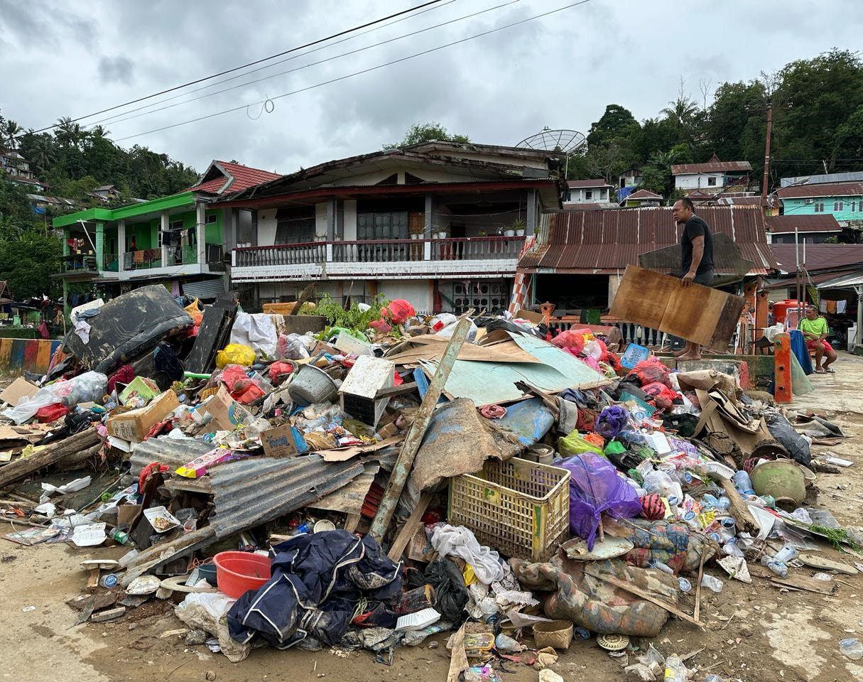 SAMPAH PASCA BANJIR : Tumpukkan sampah di Jalan Lasolo Kecamatan Kendari Barat mulai mengeluarkan bau busuk, Kamis (14/3). Warga berharap pemerintah segera mengerahkan alat berat mengangkut tumpukan sampah itu. (AGUS SETIAWAN/KENDARI POS)