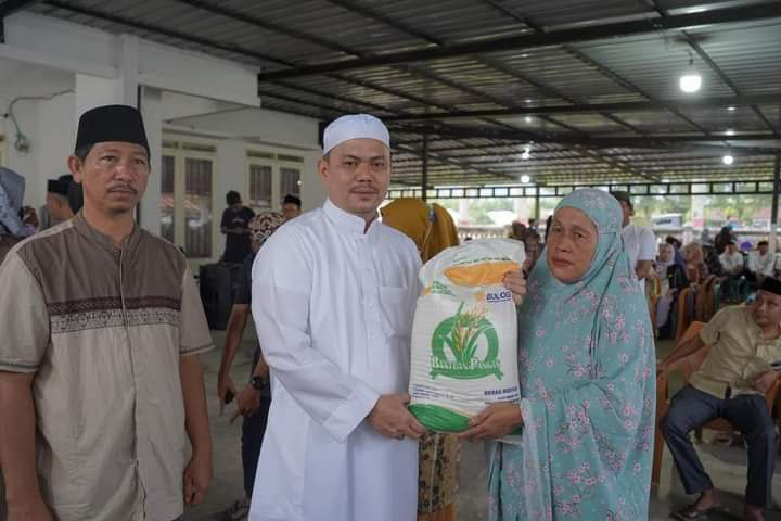 Bupati Koltim Abdul Azis (tengah) menyerahkan bantuan beras CPP kepada salah satu warga di lokasi safari Ramadan, baru-baru ini. (KUSDIN / KENDARI POS)