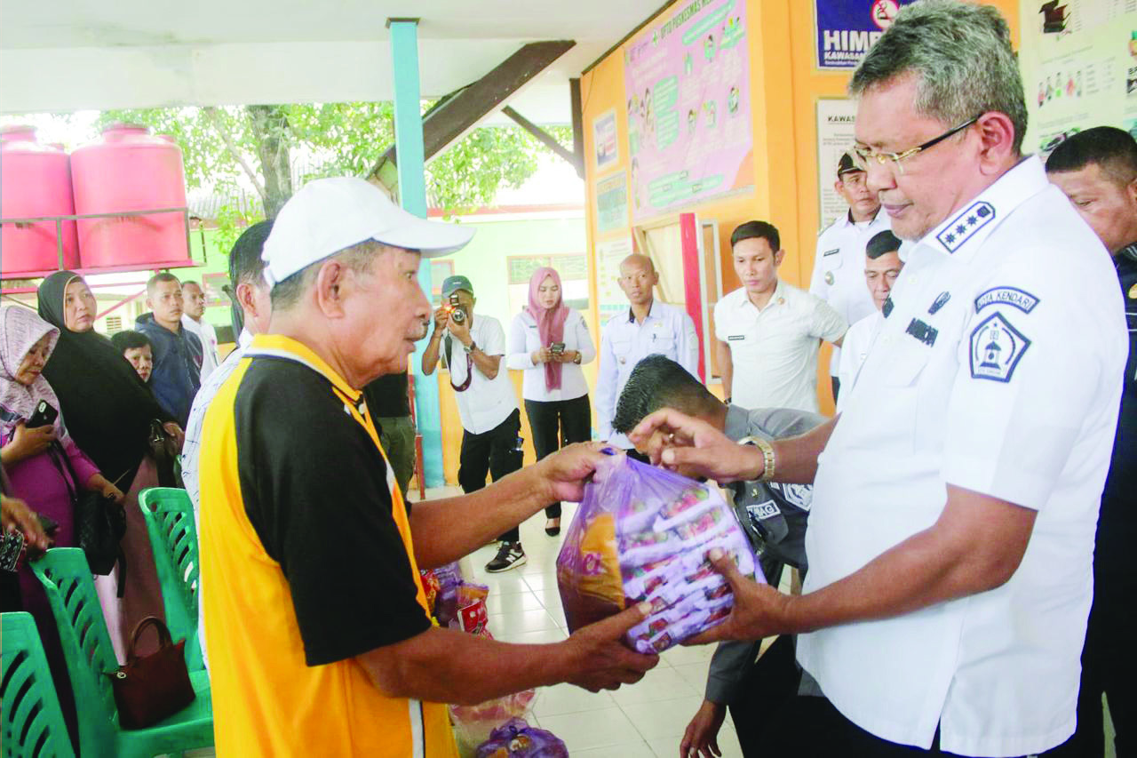 BANTUAN: Pj Wali Kota Kendari, Muh Yusup menyerahkan bantuan sembako kepada warga terdampak banjir, baru-baru ini.