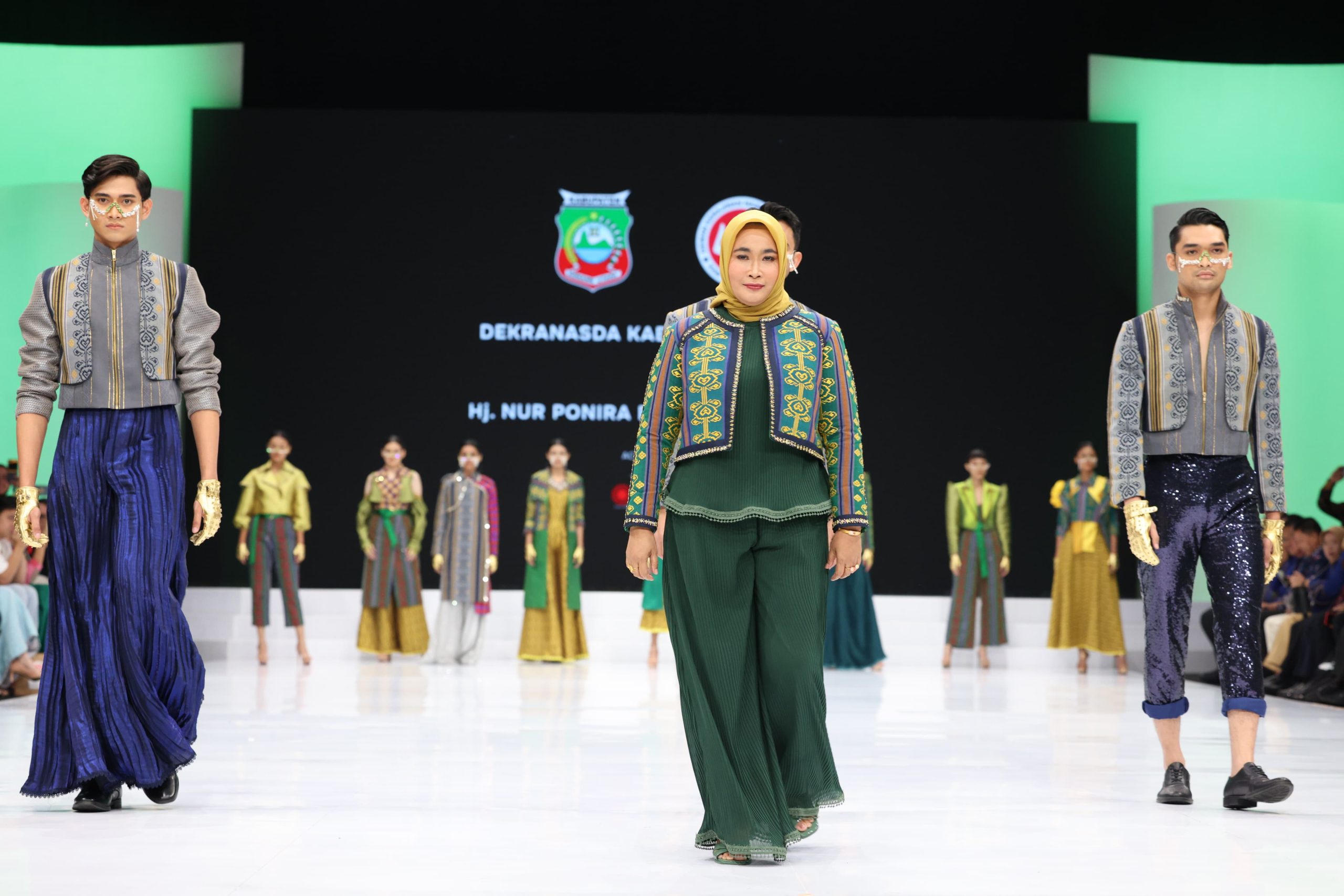 Ketua Dekranasda Konut, Hj Nurponirah Ruksamin diapit sejumlah model dalam fashion show di IFW