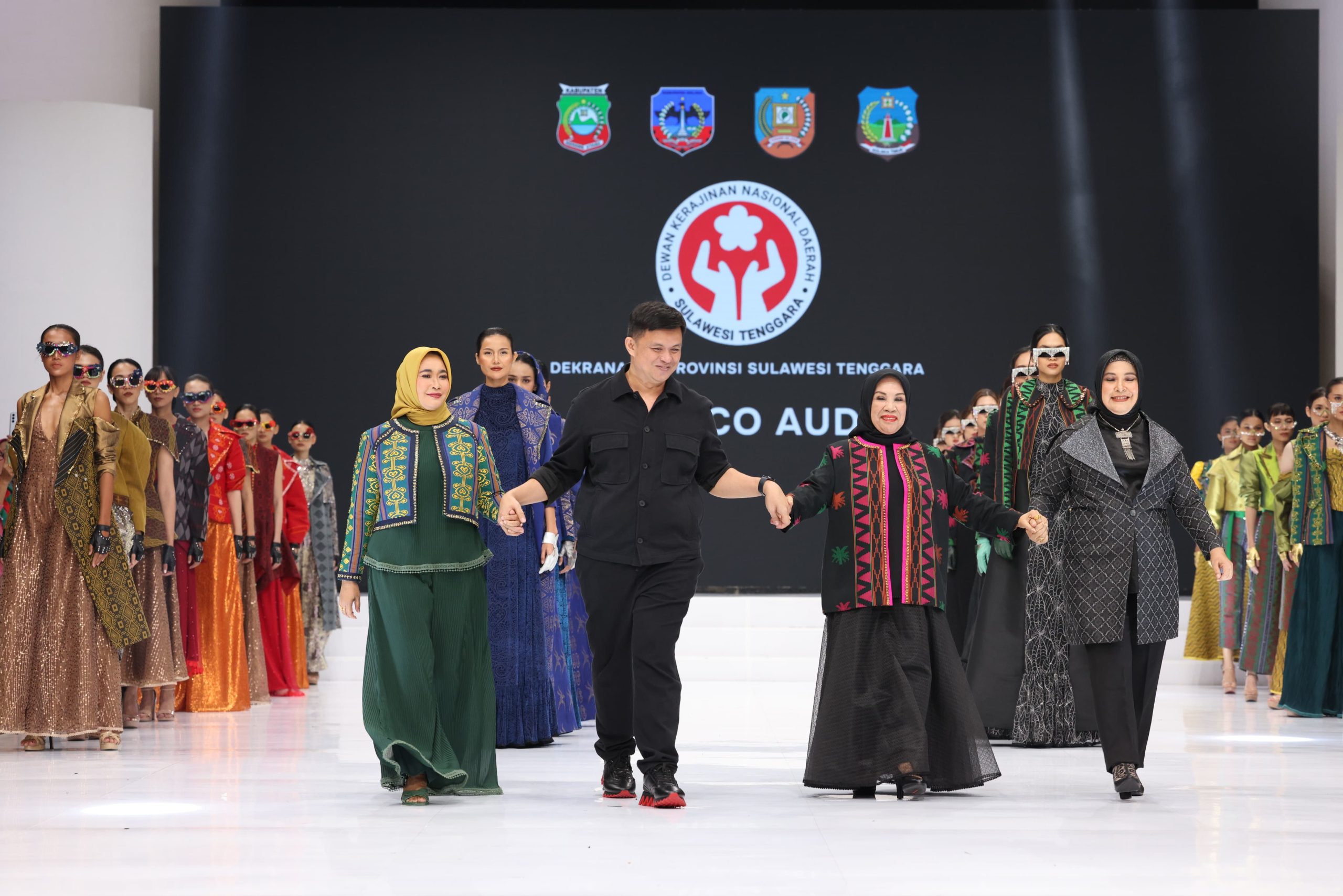 Ketua Dekranasda, Hj. Nurponirah Ruksamin (kiri), digandeng desainer ternama, Defrico Audi (tengah), saat tampil di IFW.