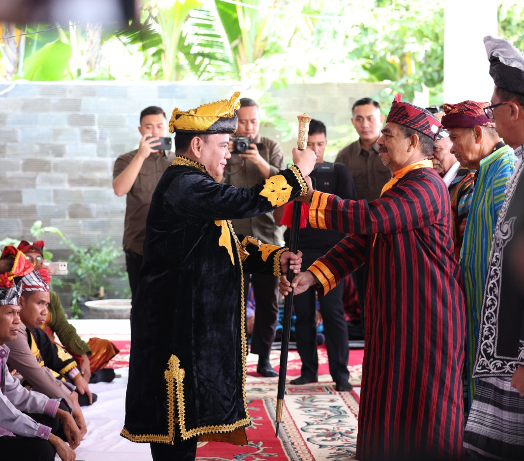 Pj Gubernur Sultra Andap Budhi Revianto (kiri) menerima tongkat kehormatan dalam prosesi penganugerahan gelar adat Kolakino Liwu Pancana dari Lembaga Adat Buton Tengah (Buteng), Jumat (19/4/2024). (BIRO ADPIM PEMPROV SULTRA)